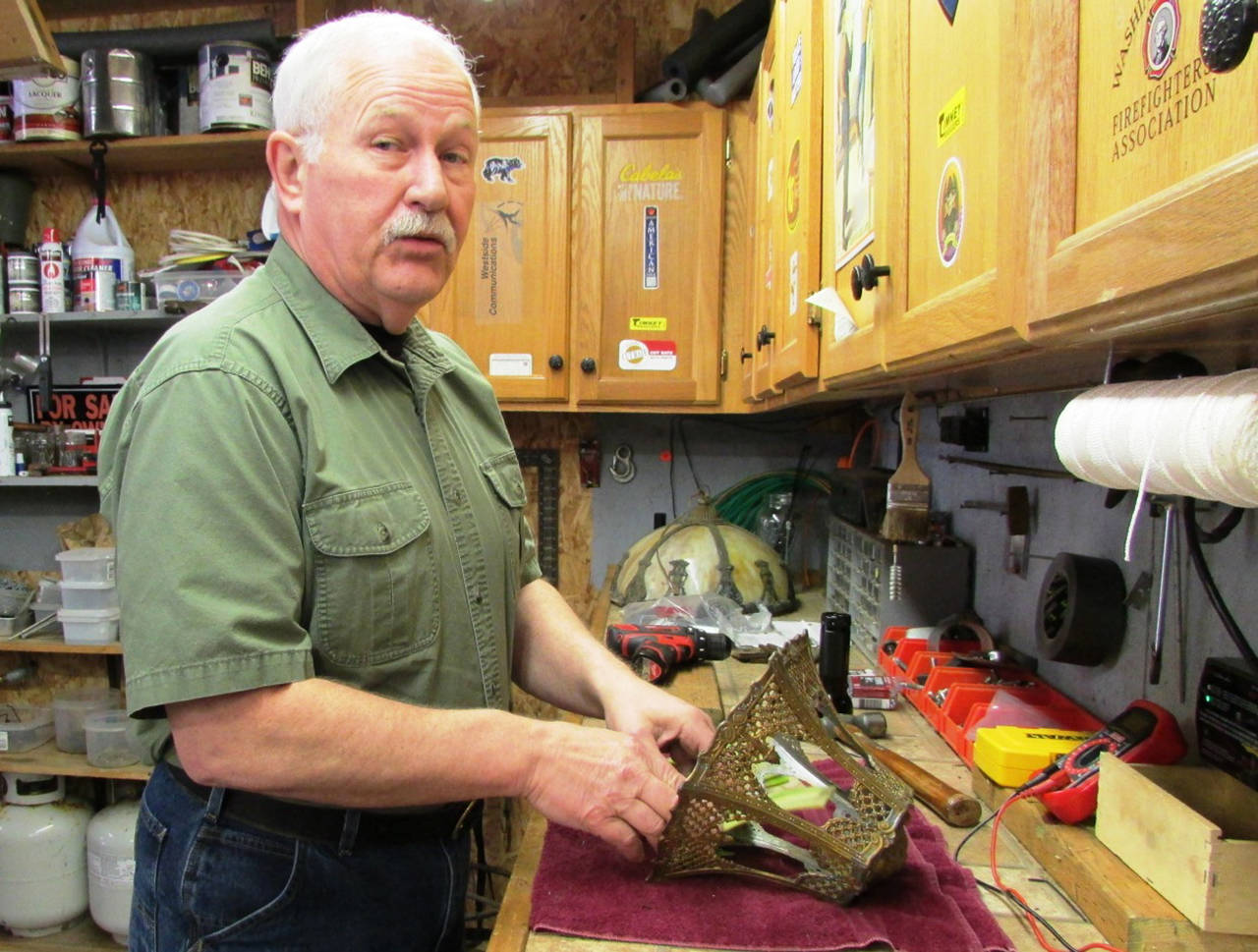 Photo by Scott D. Johnston: Puttering about his shop is one of the simple pleasures that Mike Styner now enjoys following his recent retirement as Ocean Shores Chief of Police. Here he works on an antique glass lamp shade.