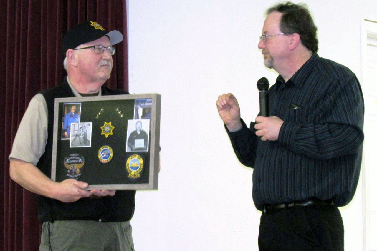 Scott D. Johnston photo: Retiring Ocean Shores Police Chief Mike Styner, left, is given a plaque with highlights of his career from St. Dave McManus.