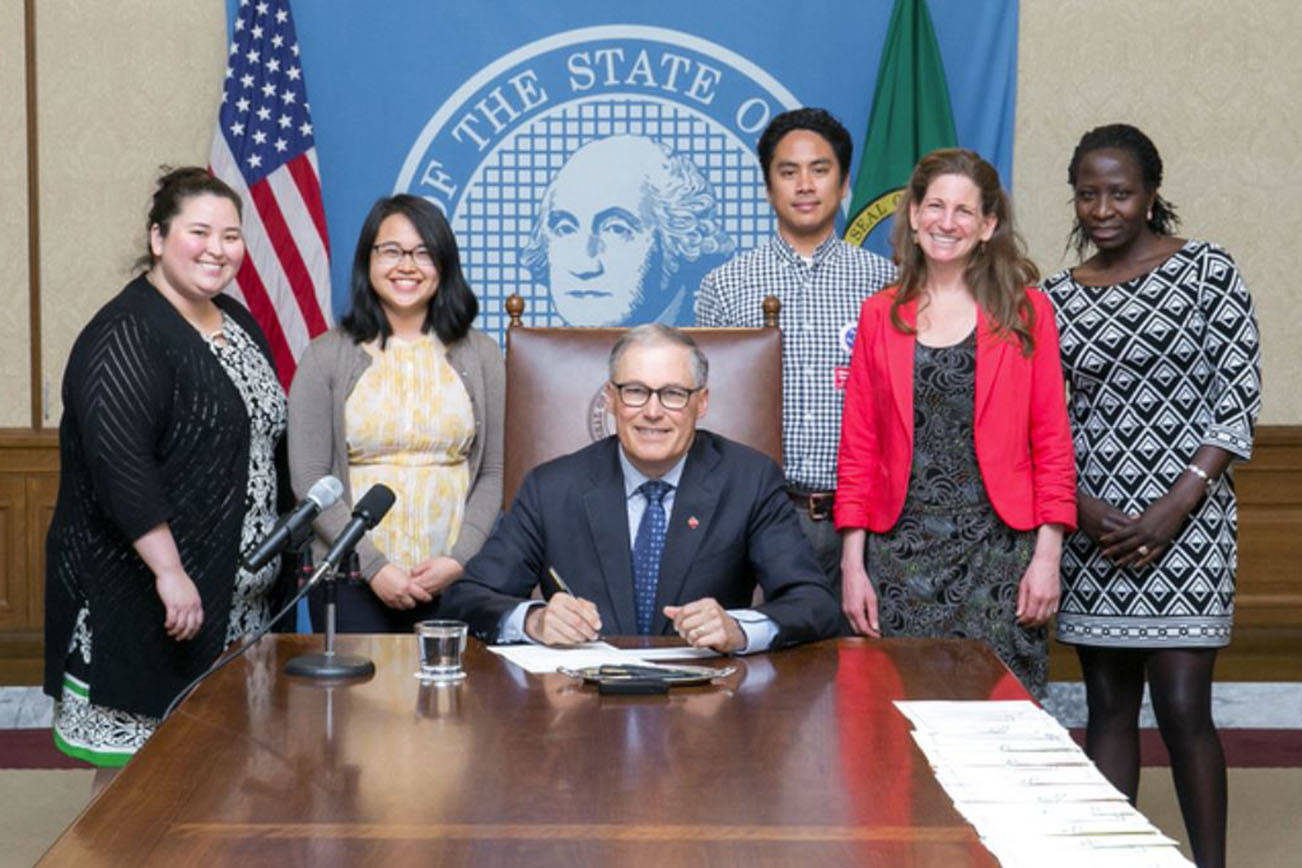 Supporters of the school safety legislation stand with Gov. Jay Inslee as he signs the bill into law on May 4. (Legislative Support Services Photography Department).