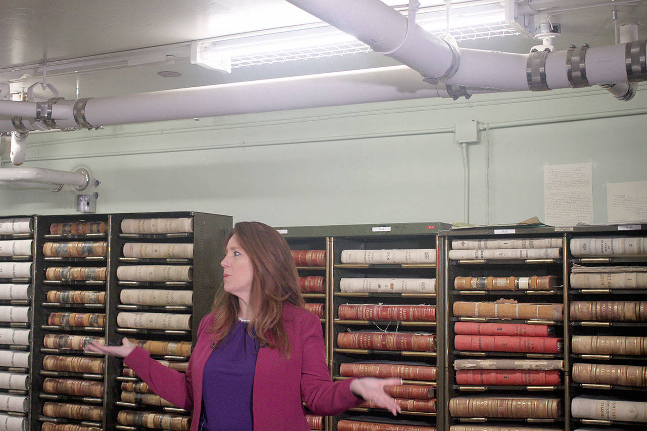 Emma Scher | Washington Newspaper Publishers Association                                Secretary of State Kim Wyman, inside the Washington State Archive building, discusses problems the building has been having with leaking pipes last month in Olympia. The pipe above her head has leaked water in the past. The room stores county records. The building was built in 1962